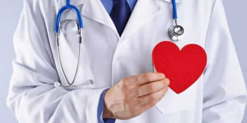 medico cardiologo tiene in mano un cuore di carta