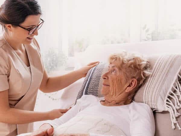 paziente anziana nel letto durante un colloquio con una psicologa a domicilio