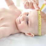 Bambino durante la misurazione della circonferenza della testa per una visita pediatrica